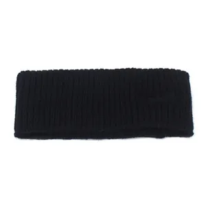 Close-up of black knitted winter headband with vertical ribbing and embossed logo