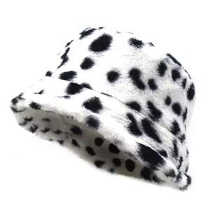 Detail of plush faux fur bucket hat featuring a vintage black and white cow print texture