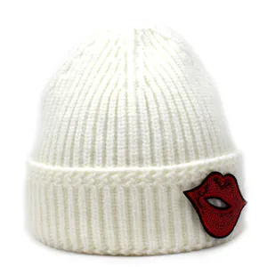 Detailansicht der weißen Strickmütze mit glitzerndem roten Lippen-Patch aus Pailletten