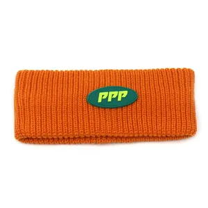Knitted sports headband in vibrant orange with green PPP logo patch and ribbed texture