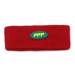 Red knit winter headband for sports featuring a green PPP logo patch with ribbed texture