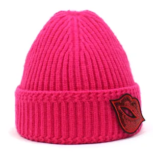 Detailansicht der Strickmütze mit Pailletten-Lippen-Patch und dicker Strickstruktur in Rosa