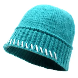 Detaillierte Strickstruktur einer cyanblauen Wintermütze mit weißer Kontrastnaht
