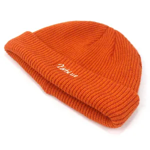 Bonnet en maille orange vif avec broderie de lettres et texture côtelée sur fond blanc