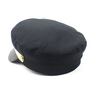Détail de la casquette marin noire avec visière en cuir et bouton doré métallique