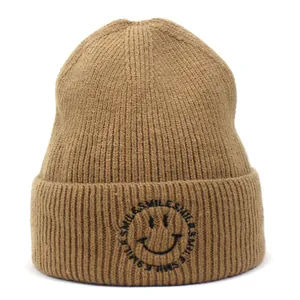 Close-up of the ribbed knit texture and black smile embroidery on the khaki beanie