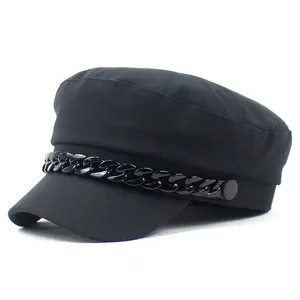 Detail view of the black nautical baker boy hat featuring a decorative glossy chain