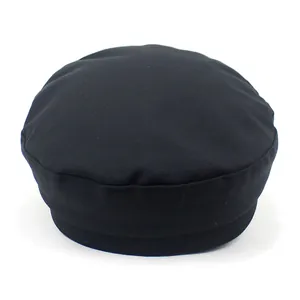 Detail view of the rounded flat top and thick band structure of this black navy cap