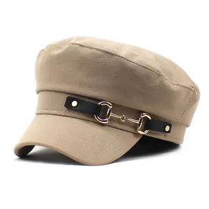Close-up of khaki newsboy hat with a black leather strap and gold horsebit buckle detail