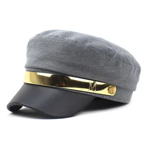 Détail du bonnet baker boy gris avec visière en cuir noir et barre métallique dorée M