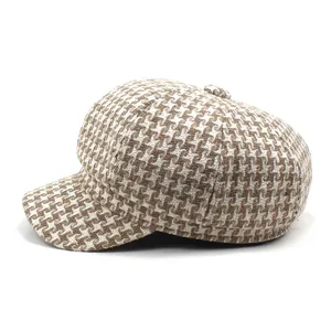 Close-up of vintage brown houndstooth newsboy hat texture and decorative top button