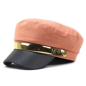 Détail de la casquette plate en sergé corail avec visière en cuir noir et charm M doré