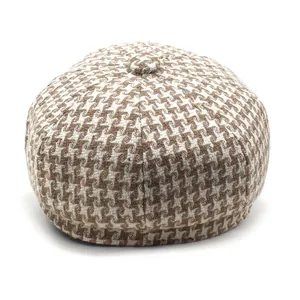 Detailed view of vintage brown houndstooth newsboy cap showing wool texture and top button