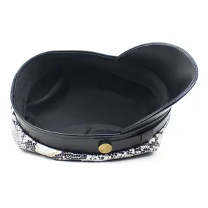 Close-up of snake skin print military hat with black PU brim and gold decorative button