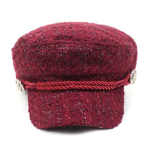 Burgundy tweed newsboy cap for women with gold buttons and woven rope trim on white background