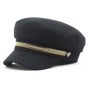 Black wool newsboy cap featuring a decorative gold fishbone chain and flat top design