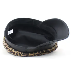 Detail view of leopard print captain hat showing inner lining and composition label