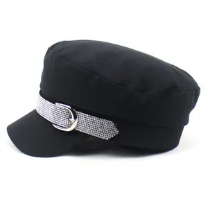 Detail of black fiddler cap with rhinestone band and silver metallic buckle ornament
