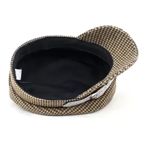 Detail of houndstooth newsboy hat showing silver rhinestone band and inner lining