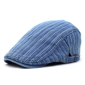 Close-up of blue striped flat cap with side metal buckle and denim fabric texture