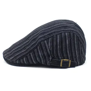 Detail of striped beret cap showing black fabric texture and brass metal side buckle