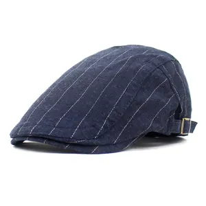 Detail of navy blue striped beret cap showing side metal buckle and denim texture