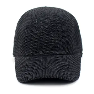 Close-up of black woven straw texture on a breathable summer baseball cap with curved brim