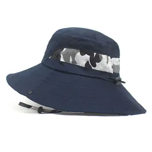 Detail of navy sun hat featuring camouflage trim, wide brim, and adjustable wind cord