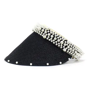Detail of black straw visor with large white pearl embellishments and woven texture