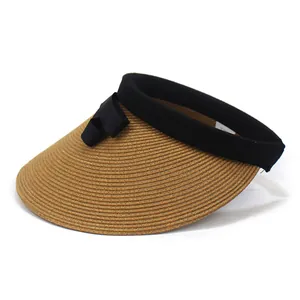 Detail of summer straw sun hat showing woven texture, black ribbon bow, and inner size label