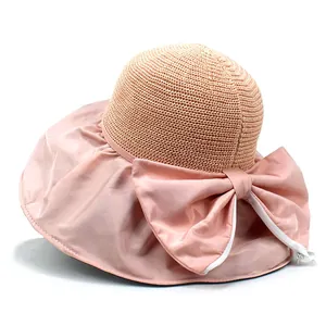 Detail of pink wide brim sun hat with woven straw crown and large decorative bow