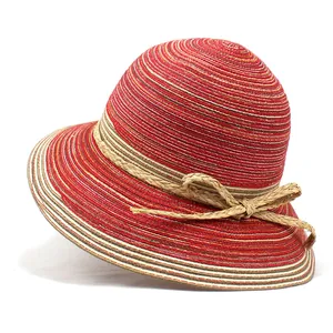 Détail d'un chapeau de paille rayé avec nœud tissé et bords ondulés élégants