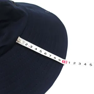Detail showing the 10cm wide brim of this navy blue sun hat with a measuring tape