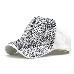 Close-up of sparkling silver rhinestones on the brim of a white cotton baseball cap
