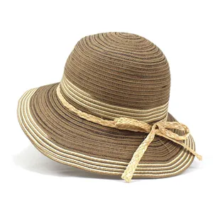 Détail d'un chapeau de paille tressé bicolore avec un nœud beige et texture fine
