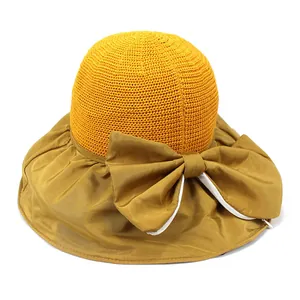 Detail of yellow wide brim sun hat showing knitted crown and large decorative bow