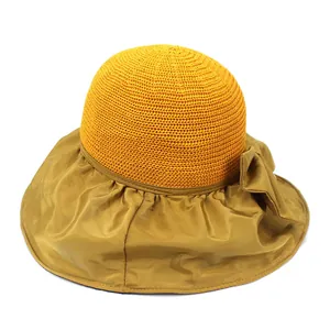 Detailed texture of knitted yellow crown and wide brim sun hat with bow decoration
