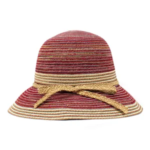 Détail d'un chapeau de paille tressé multicolore avec rayures rouges et nœud en paille
