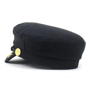 Detail of black wool military cap with gold anchor button, braided rope, and embroidery