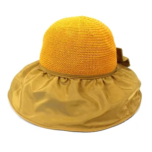 Detail of wide brim straw sun hat with black vinyl lining and decorative bowknot