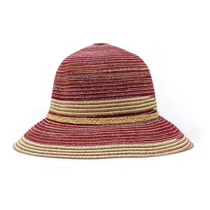 Détail d'un chapeau de soleil tressé tricolore à rayures rouges et beige avec ruban brun