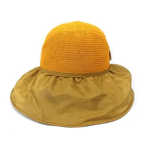 Detail view of the yellow woven crown and silk-like brim on this foldable sun hat