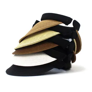 Close-up of multicolored woven straw sun hats stacked with flexible black headbands