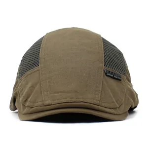Detail of dark brown newsboy cap with breathable mesh panel and metal logo plate