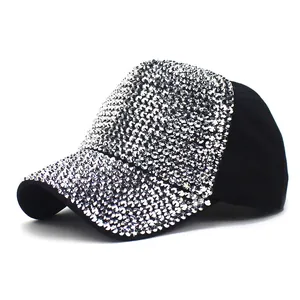 Detailed view of silver rhinestones on a black curved brim baseball cap with sparkles
