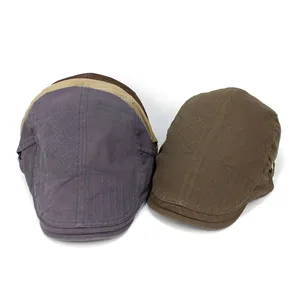 Detail of cotton flat caps in grey, brown and khaki with embroidered geometric patterns