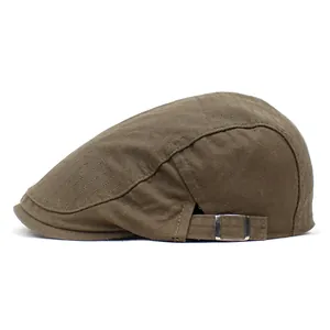 Side view of dark brown canvas flat cap showing twill texture and metal buckle