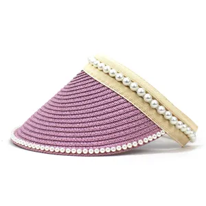 Detailed view of lavender straw sun visor with pearl accents and beige fabric strap