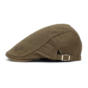 Detail of BG embroidery and adjustable metal buckle on vintage brown cotton beret hat