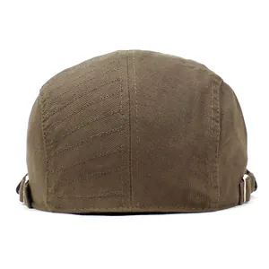 Detail view of the adjustable metal buckle and stitching on a brown cotton flat cap